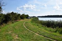 grobla przy zalewie, w tle policyjny parawan i funkcjonariusze służb