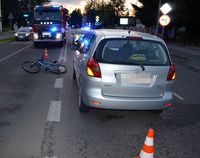 na jezdni leży rower obok stoi osobowa toyota, w tle wóz strażacki i radiowóz