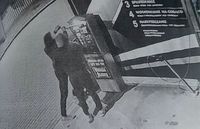 zdjęcie z nagrania z kamery dwaj mężczyźni przy urządzeniu do wpłacania pieniędzy na myjni samochodowej