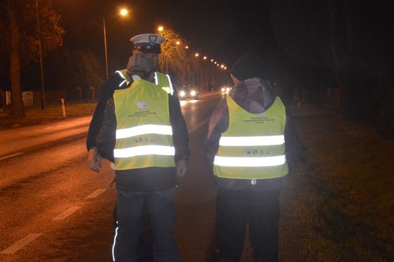 policjant oraz dwie osoby piesze w kamizelkach odblaskowych