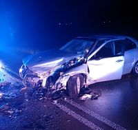 Droga, miejsce wypadku. Na jezdni w poprzek stoi osobowa Alfa Romeo.