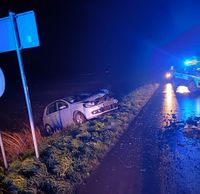 Droga, miejsce wypadku. W przydrożnym rowie osobowy Volkswagen. W tle na jezdni stoi policyjny radiowóz.