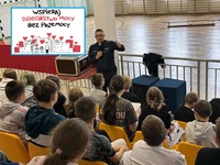 policjant i młodzież w czasie spotkania profilaktycznego, na zdjęciu naniesiony plakat kampanii Dzieciństwo bez przemocy