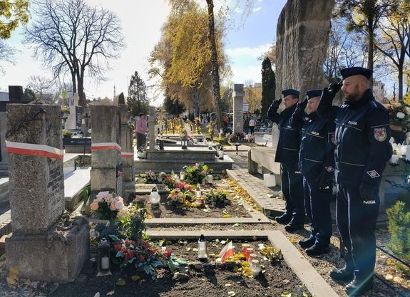 policyjna delegacja oddaje honor przed grobami