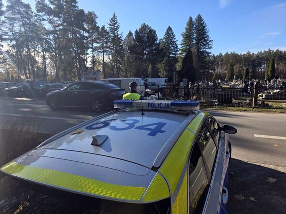 policyjny radiowóz przed cmentarzem