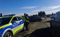 policjanci obok radiowozu na parkingu