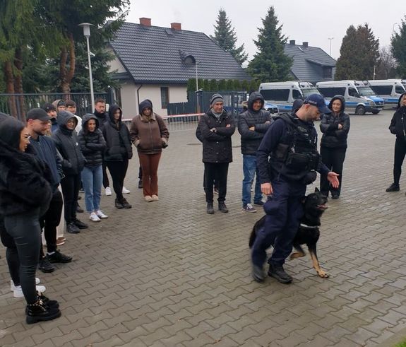 przewodnik z policyjnym psem realizuje pokaz dla młodzieży