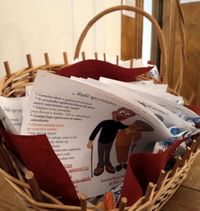 w wiklinowym koszyku leżą ulotki informacyjne dla osób starszych