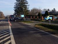 Droga, gdzie doszło do zderzenia fiata z fordem. Na poboczu stoją dwa uszkodzone samochody, w uliczce do posesji stoi radiowóz a na drodze za pojazdami osobowymi stoi wóz strażacki