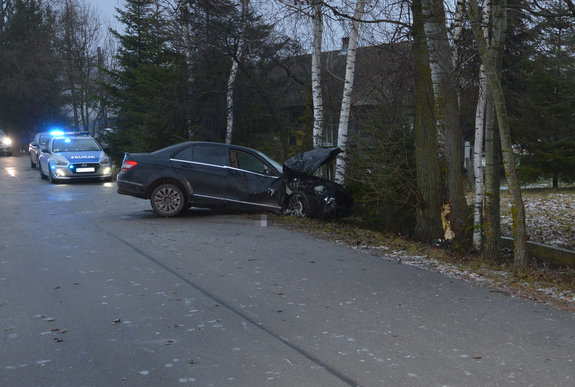 na jezdni stoi radiowóz, przed nim w przydrożnym rowie osobowy mercedes