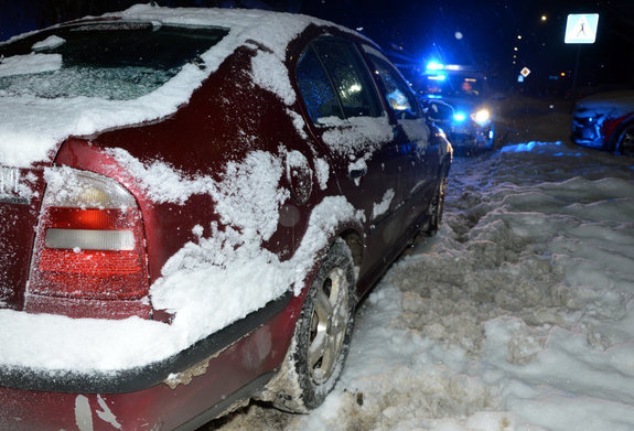 zaparkowana na poboczu drogi w śniegu skoda, w tle policyjny radiowóz