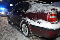 zaparkowana na poboczu drogi w śniegu skoda, w tle policyjny radiowóz