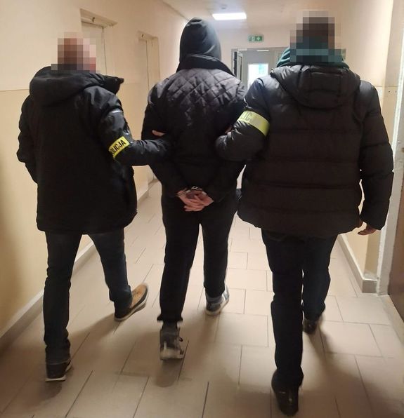 policjanci kryminalni prowadzą zatrzymanego