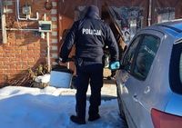 policjant niesie w wiadrze drewno