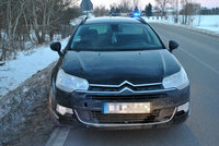 na poboczu drogi stoi osobowy citroen za nim radiowóz