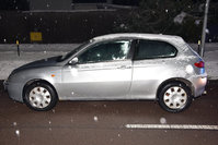 osobowy pojazd marki Alfa Romeo zaparkowany na poboczu drogi