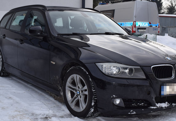 zabezpieczone przez policjantów osobowe BMW w tle policyjny radiowóz