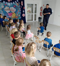 policjant w czasie spotkania profilaktycznego rozmawia z przedszkolakami