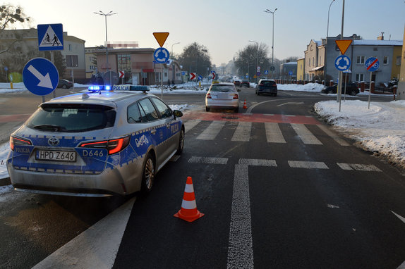 rondo i przejście dla pieszych, przed rondem stoi radiowóz a przed radiowozem osobowa skoda