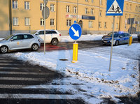 rondo i przejście dla pieszych, przed rondem dwa pojazdy osobowe, za jednym z nich stoi radiowóz