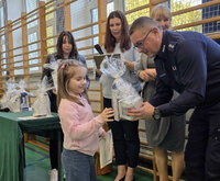 policjant wręcza dziewczynce nagrodę