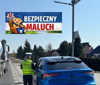 policjantka kontroluje samochó2d osobowy, w górnej części zdjęcia logo komendy Miejskiej Policji w Zamościu i napis Bezpieczny Maluch