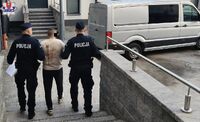 dawaj policjanci doprowadzają zatrzymanego do radiowozu