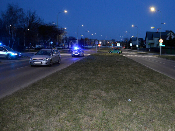 droga i przejście dla pieszych na którym została potrącona kobieta, przed przejściem stoi osobowy hyundai a w bocznej uliczce radiowóz