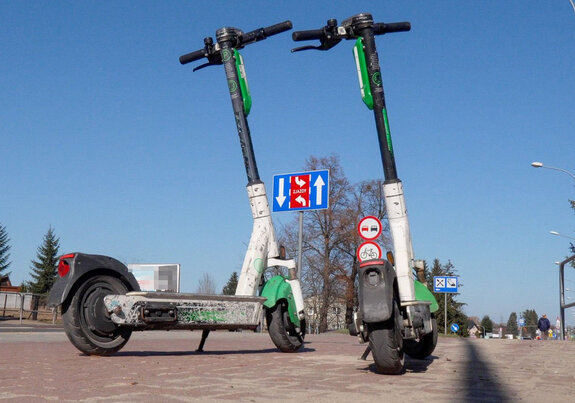 zdjęcie poglądowe dwie stojące na chodniku hulajnogi elektryczne