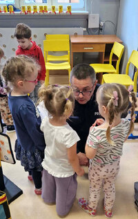 policjant wśród dzieci podczas spotkania profilaktycznego