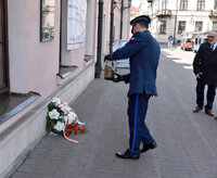 I Zastępca Komendanta Miejskiego Policji w Zamościu stawia znicz przed tablicą upamiętniającą zamordowanych policjantów Policji Państwowej