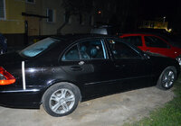 zaparkowany przed blokiem stojący bokiem osobowy mercedes