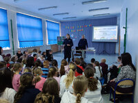 dwie policjantki stoją przed uczniami w czasie spotkania profilaktycznego