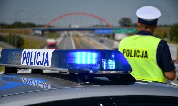 odwrócony tyłem policjant i radiowóz