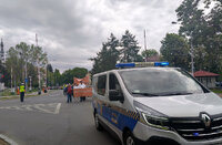 uczestnicy Marszu Godności , wóz straży miejskiej i stojący na drodze policjant