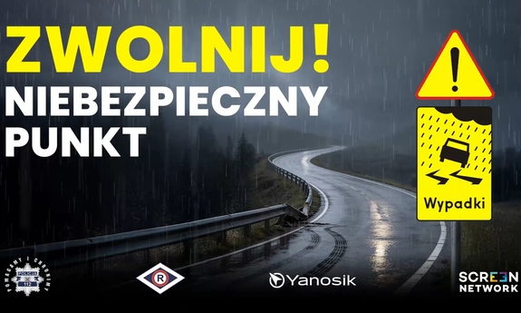 droga w nocnej scenerii i napis Zwolnij niebezpieczny punkt