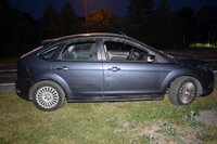 zaparkowany na trawie stojący bokiem osobowy ford