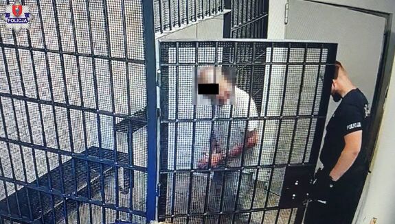 policjant prowadzi zatrzymanego
