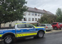radiowóz na poboczy, na parkingu policjant bada trzeźwość siedzącego w samochodzie osobowym kierowcy