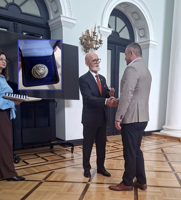 Wiceminister Zdrowia wręcza odznaczenie policjantowi