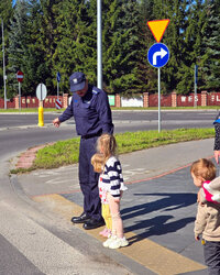 policjant z dwójka dzieci przed przejściem dla pieszych
