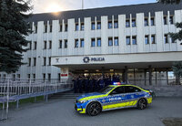 policjanci przed budynkiem Komendy Miejskiej Policji w Zamościu, przed nimi radiowóz