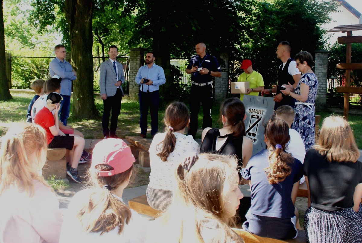 pogadanka z uczniami przed szkołą z udziałem policjanta i innych osób z instytucji publicznych 