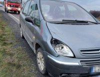 uszkodzony przód citroena stojący na drodze, za nim pojazd straży pożarnej i radiowóz policji